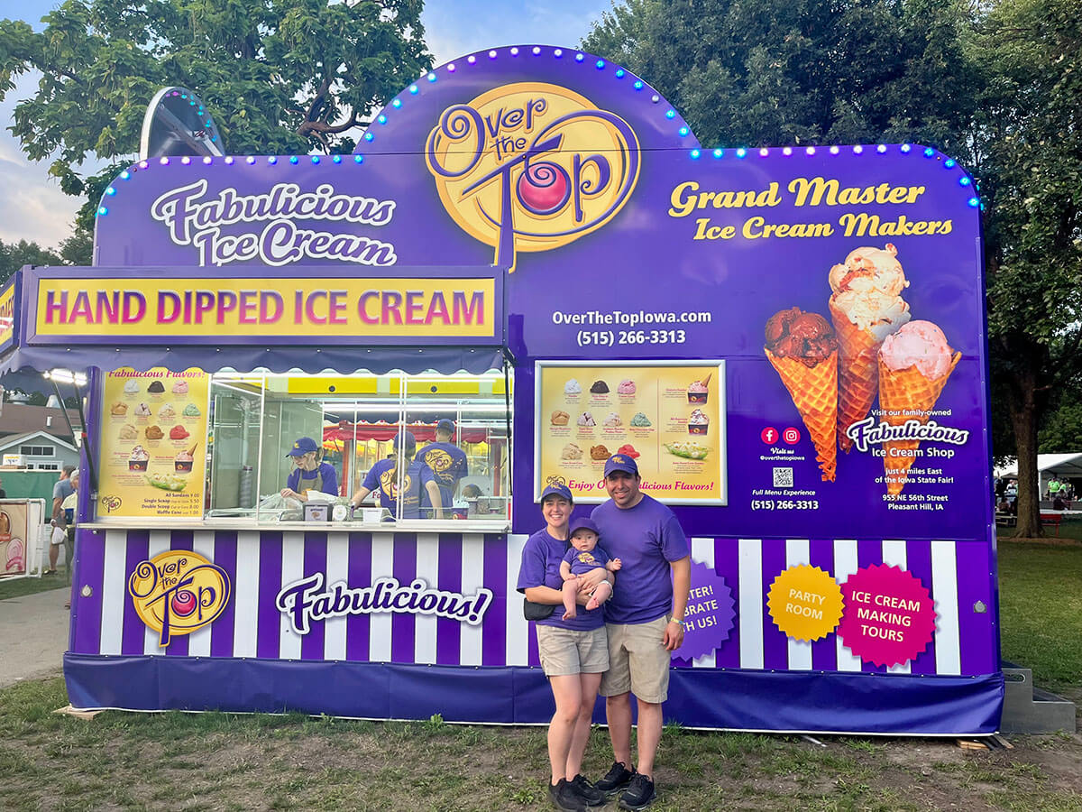 The Over The Top Ice Cream truck set up on a fairground, with Dani, Nat, and Andres posing in the front.